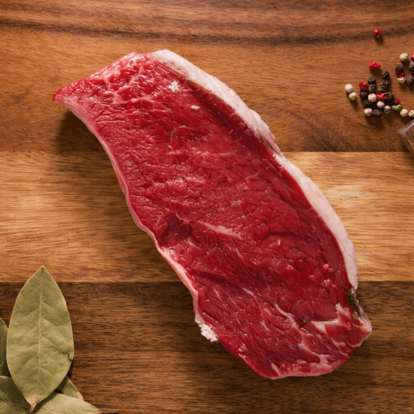 Bisteque crudo sobre tabla de madera